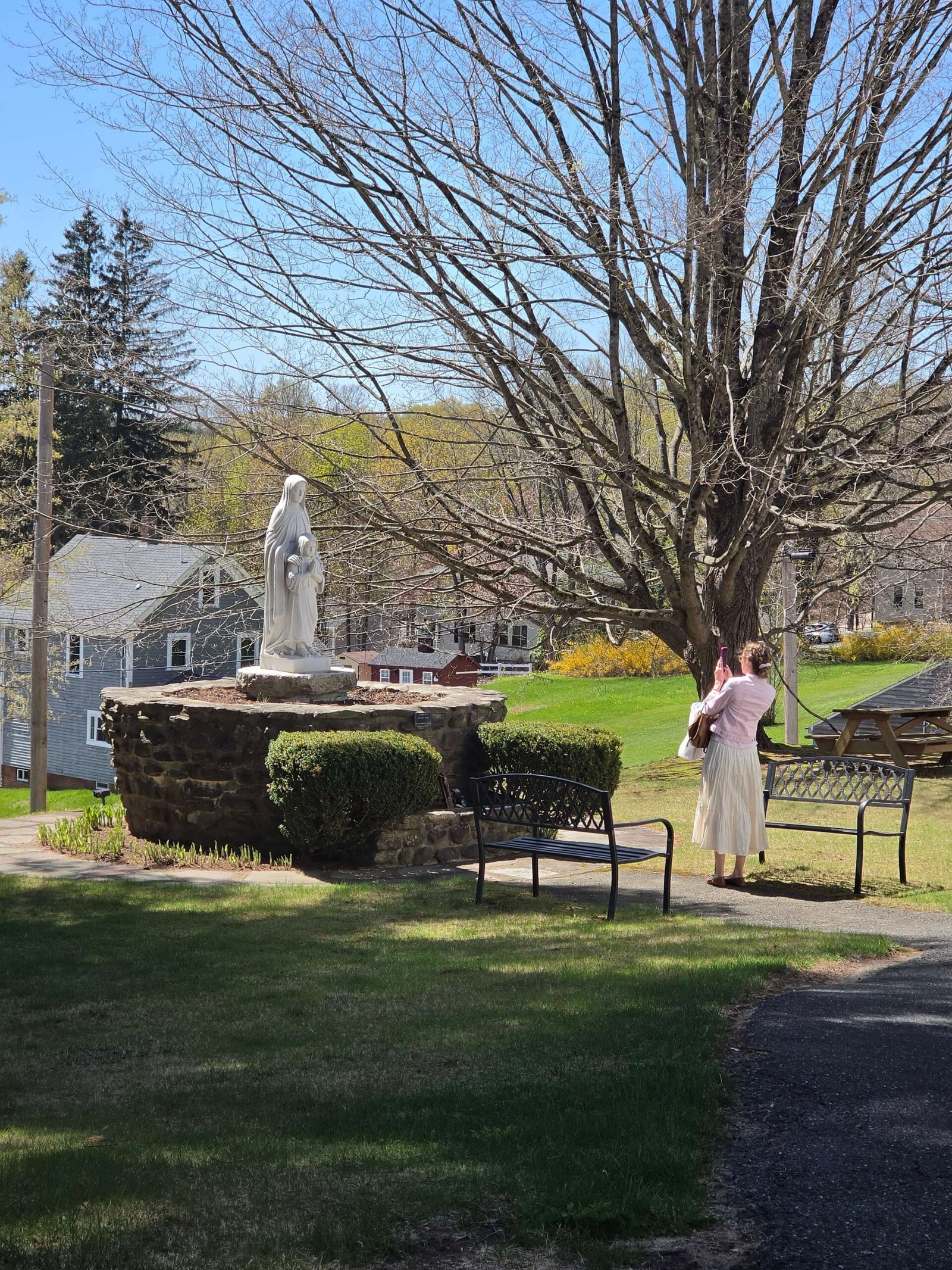 Megan standing in front of of a statue of St Anne and a young Mother Mary