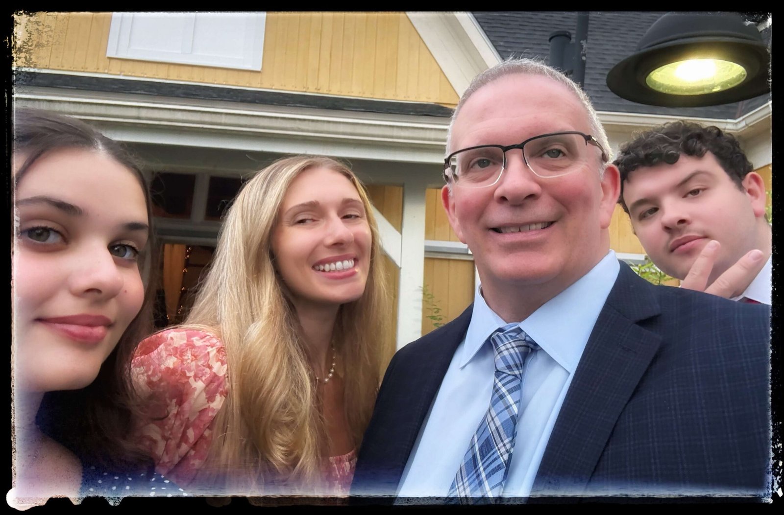 Myself, Megan, MJ and Emma standing in front of a yellow barn dressed for a friends wedding 